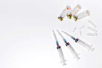 Used medical vials, ampoules and hypodermic syringes isolated on white background. Treatment, cure background, copy space