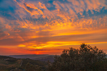 Beautiful wide angle view of colorful sunset sky over the Tuscany hills