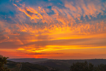 Fototapeta premium Beautiful wide angle view of colorful sunset sky over the Tuscany hills