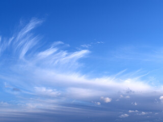 Beautiful picturesque unusual white feather clouds in the blue sky, magic romantic background. Large Bird Feather Cloud