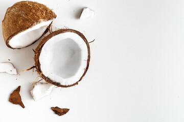 Fototapeta na wymiar Cracked coconut with pieces on the white background. tropical concept