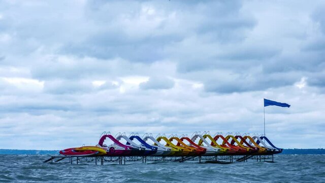 Time-lapse view on the water paddle bikes beach boats on the Balaton Lake on a stormy day.