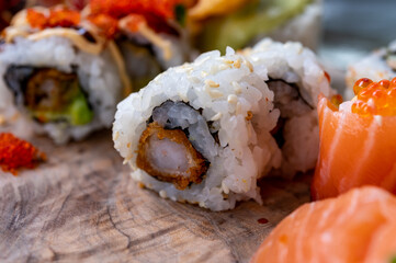 Japanese food, sushi or sashimi made from rice with salmon, avocado, cucumber, red fish caviar, tempura shrimps