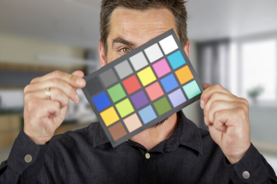 The model holds a color card in its hands for correct color transfer during further color correction. Color checker card.