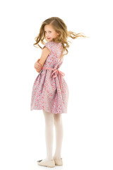 Smiling Blonde Girl with Long Hair Standing Holding Hem of her Dress.