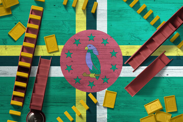Dominica flag with national background with dominoes on wooden table. Top view. Concept of game.
