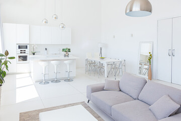 Cozy luxury modern interior design of a studio apartment in extra white colors with fashionable expensive furniture in a minimalist style. white tiled floor, kitchen, relaxation area and workplace