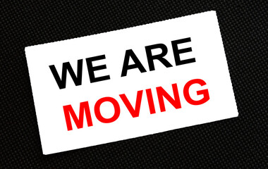 White card on the black background with text We Are Moving
