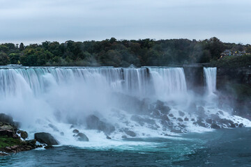 Fototapeta premium Thunderous Niagara waterfalls in night with colorful lights in Niagara, Ontario, Canada