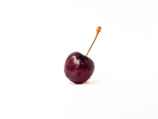 Black ripe juicy cherry on a white background with drops of water. A place for text.