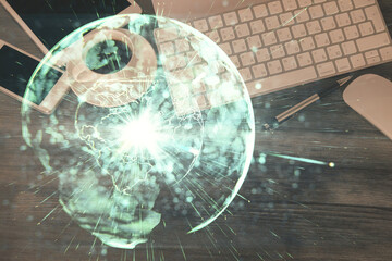 Double exposure of business theme hologram over desktop with phone. Top view. Mobile international trade connection concept.