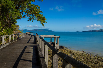 Wooden boardwalk on sunny rocky shores. Daytime, Long Island, Queensland, Australia. 