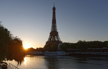 Fototapeta na wymiar Romantic sunrise background. Eiffel Tower with boats on Seine river in Paris .