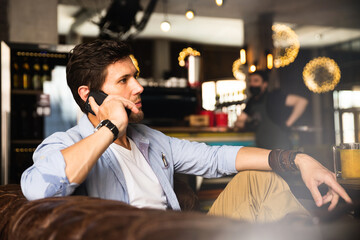 Serious concentrated male entrepreneur having a business call in cafe