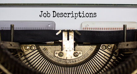 Text 'Job Descriptions' typed on retro typewriter. Business concept.