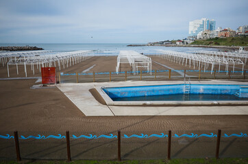 Half filled swimming pool with dirty water at closed empty beach during quarantine in Mar del Plata, Argentina.