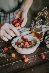 A delicious and healthy breakfast with raspberries and honey. Oatmeal for breakfast. Morning aesthetics and beautiful layout on a wooden table.