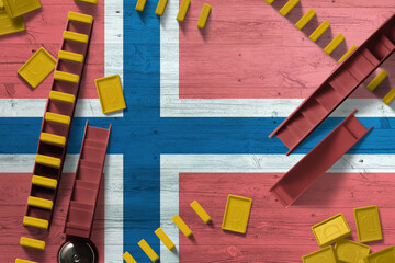 Norway flag with national background with dominoes on wooden table. Top view. Concept of game.