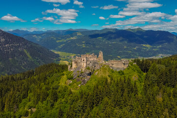 Fototapeta na wymiar Aerial drone panorama of Steinschloss castle ruins rising above the mura valley in styria, Austria. Medieval ruins in Austria on a sunny day.