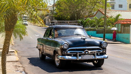 Havana, Cuba. Old American Cars in traffic on a wide boulevard at a tunnel entrance.