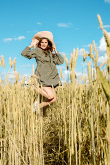 Vertical portrait of beautiful young woman in the field. girl in ears of wheat on summer field outdoors, fashion and model teenager.freedom concept, hot summer.