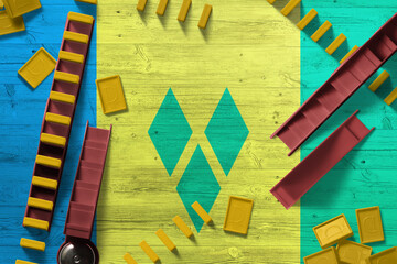 Saint Vincent And The Grenadines flag with national background with dominoes on wooden table. Top...