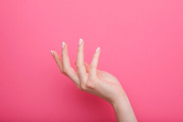 Beautiful female hands with stylish nail manicure gel polish on pink  background. Free space for text.