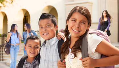 Young Hispanic Student Children Wearing Backpacks On School Campus