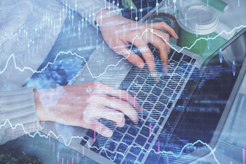 Double exposure of woman hands typing on computer and forex chart hologram drawing. Stock market invest concept.