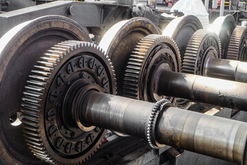 Driving wheelset with gears in a repair depot. Cogwheels of traction gears of traction rolling...