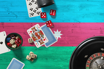 Azerbaijan casino theme. Aces in poker game, cards and chips on red table with national wooden flag background. Gambling and betting.