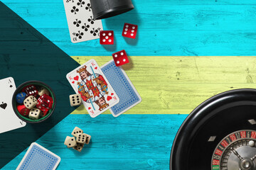 Bahamas casino theme. Aces in poker game, cards and chips on red table with national wooden flag background. Gambling and betting.