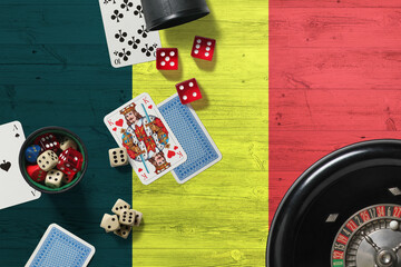 Belgium casino theme. Aces in poker game, cards and chips on red table with national wooden flag background. Gambling and betting.