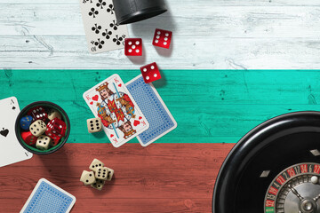 Bulgaria casino theme. Aces in poker game, cards and chips on red table with national wooden flag background. Gambling and betting.