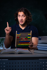 Young male student in the classroom at night