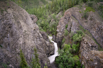 Cascading waterfall with rock face sides in northern Canada, Yukon Territory. Taken in the summer. 