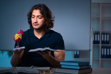 Young male student in the classroom at night