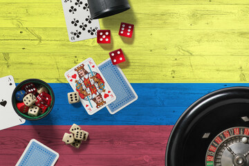 Colombia casino theme. Aces in poker game, cards and chips on red table with national wooden flag background. Gambling and betting.