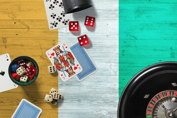Cote D'Ivoire casino theme. Aces in poker game, cards and chips on red table with national wooden...