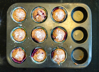 baked cupcake cakes in a muffin tin and eggshells isolated with shadows on a white background, high angle view from above, copy space