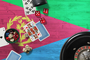 Eritrea casino theme. Aces in poker game, cards and chips on red table with national wooden flag background. Gambling and betting.