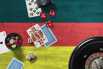 Germany casino theme. Aces in poker game, cards and chips on red table with national wooden flag background. Gambling and betting.