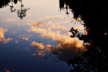 Clouds reflected in water with ripples during sunset