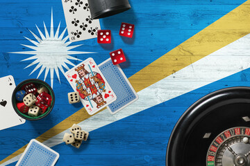 Marshall Islands casino theme. Aces in poker game, cards and chips on red table with national wooden flag background. Gambling and betting.