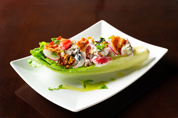 cobb salad with bacon, blue cheese, walnut, tomato, radish blueberry with creamy dressing in lettuce leaf cup