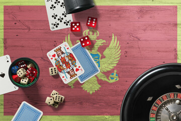 Montenegro casino theme. Aces in poker game, cards and chips on red table with national wooden flag background. Gambling and betting.