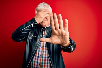 Senior handsome hoary man wearing casual shirt and jacket over isolated red background covering eyes with hands and doing stop gesture with sad and fear expression. Embarrassed and negative concept.