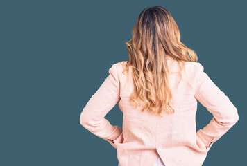 Young caucasian woman wearing business clothes standing backwards looking away with arms on body