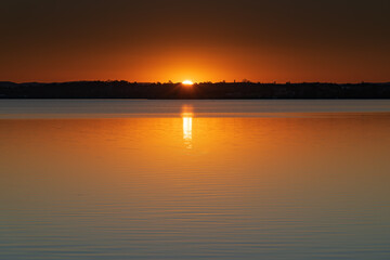 Fototapeta na wymiar Sunset over the Lake with Clear Skies