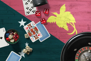 Papua New Guinea casino theme. Aces in poker game, cards and chips on red table with national wooden flag background. Gambling and betting.